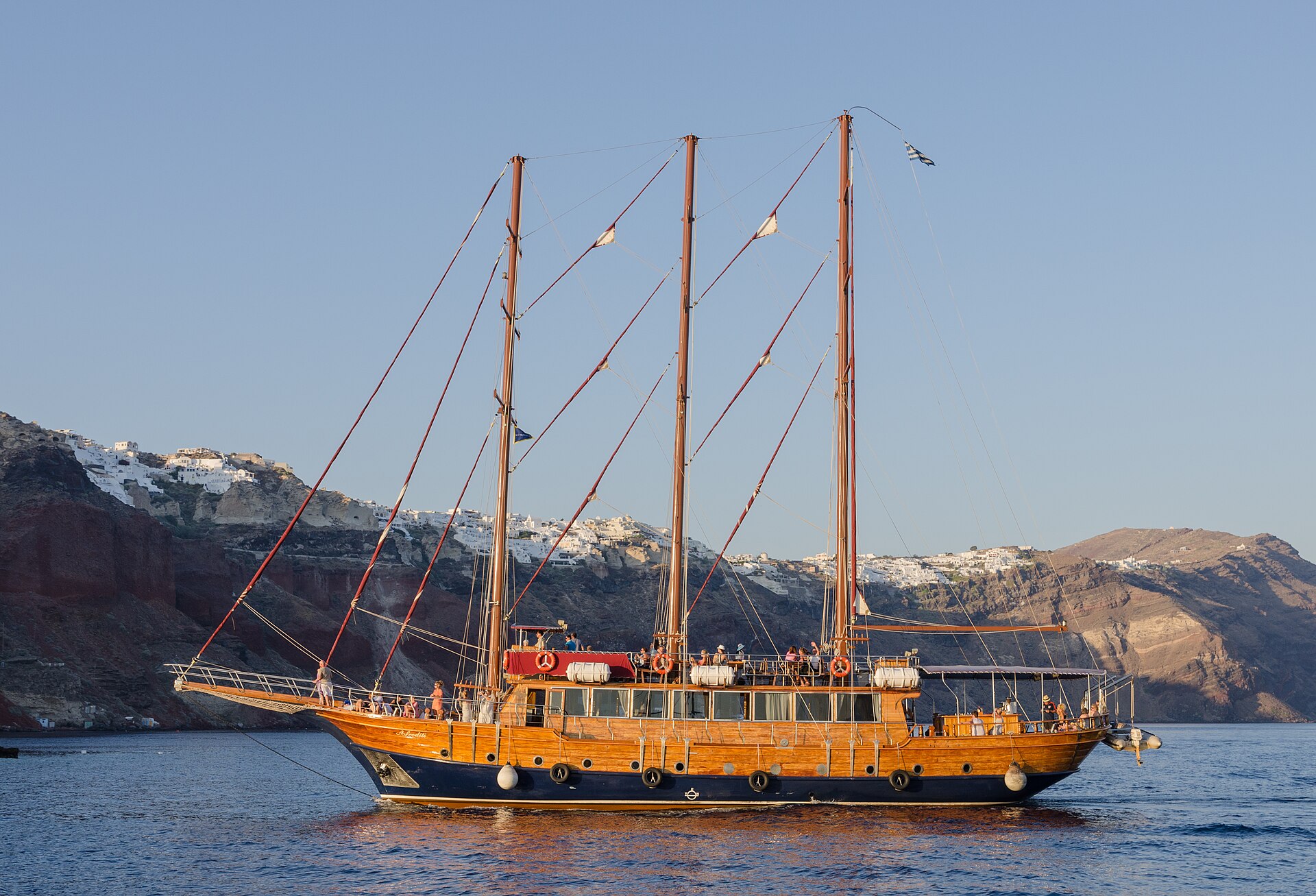 Tour boat on the water below the cliffs of Santorini