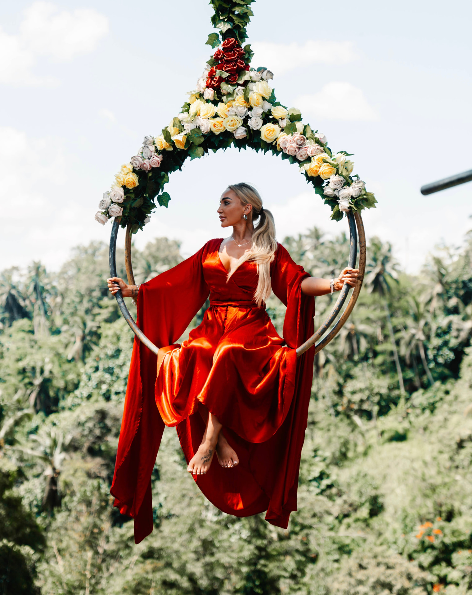 JetQuest traveler on the Bali jungle swing in a red dress