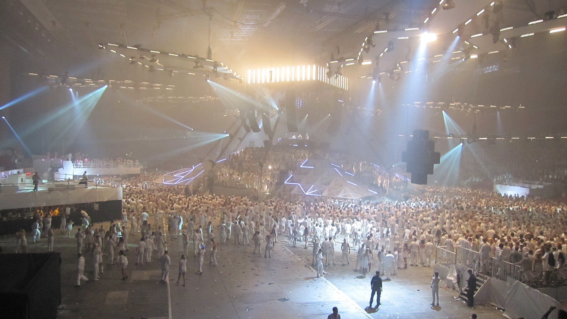 All-white party with a crowd dressed in white under stage lights